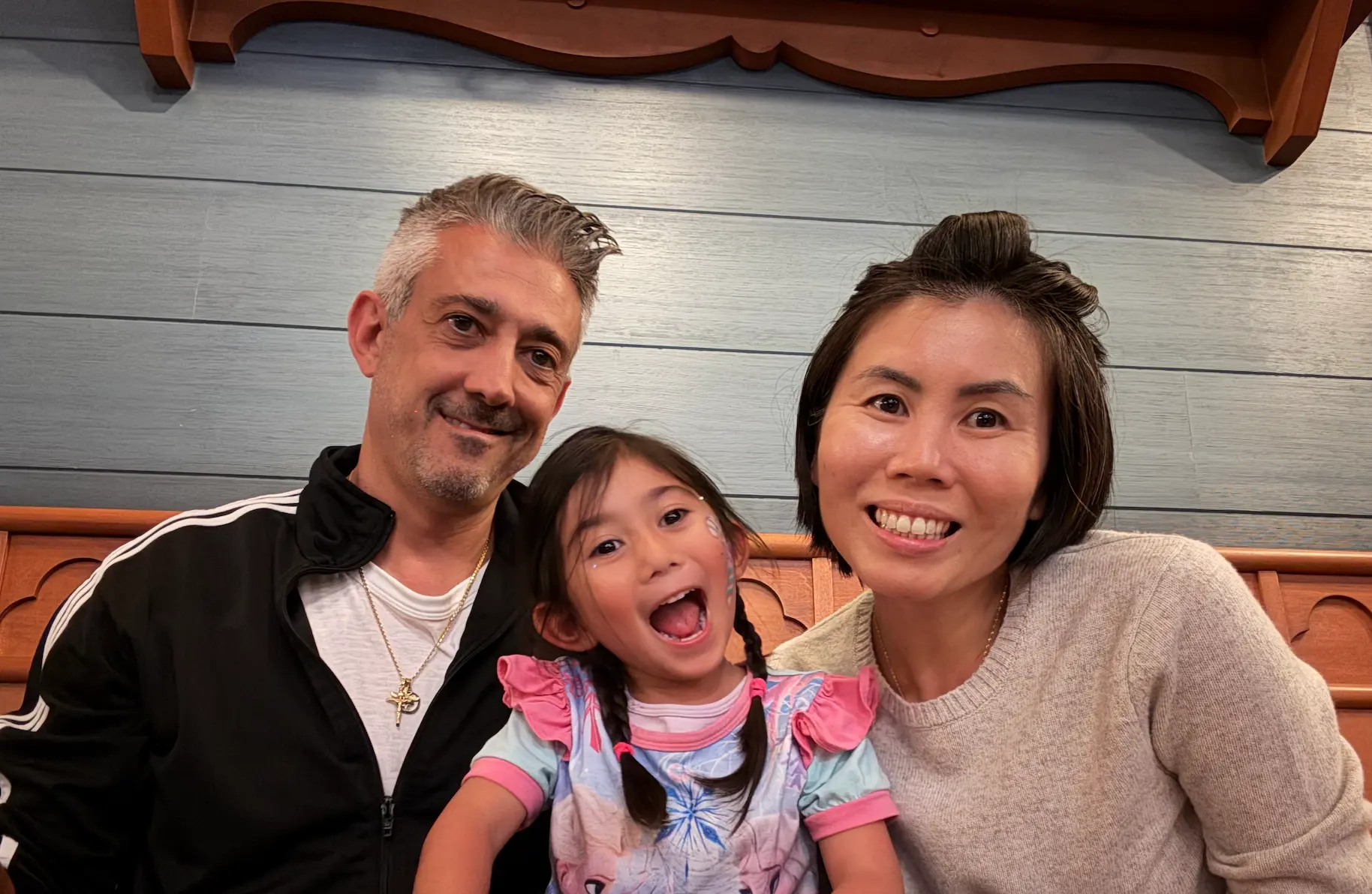 Amie, your host, smiling with her family in a warm indoor photo